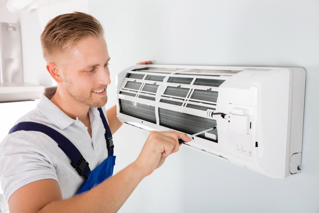 HVAC technician performing ductless air conditioning maintenance in Lehi