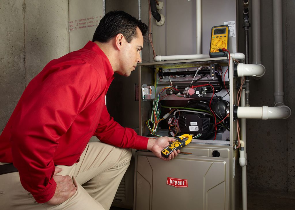 HVAC technician repairing an indoor furnace in Lehi