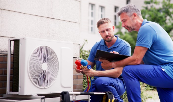 HVAC technicians installing an outdoor air conditioning unit in Lehi