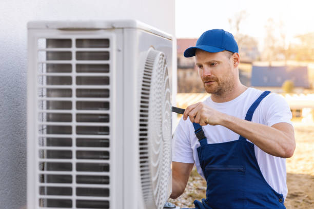 HVAC technician servicing an outdoor air conditioning unit in Lehi