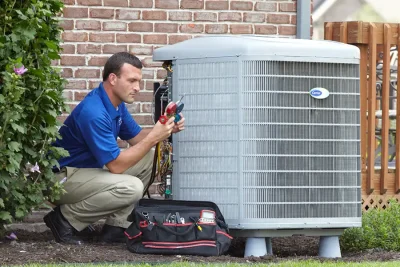 design-air-heating-and-air-conditioning-decatur-il-05 – Copy HVAC technician inspecting an outdoor air conditioning unit in Lehi, UT